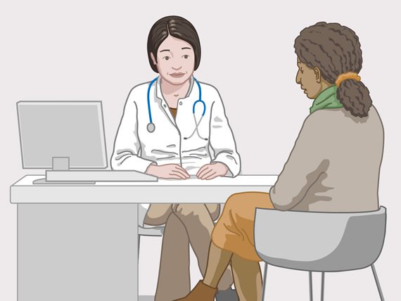 En kvinne snakker med legen.
